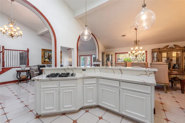 a room with furniture a chandelier and wooden floor