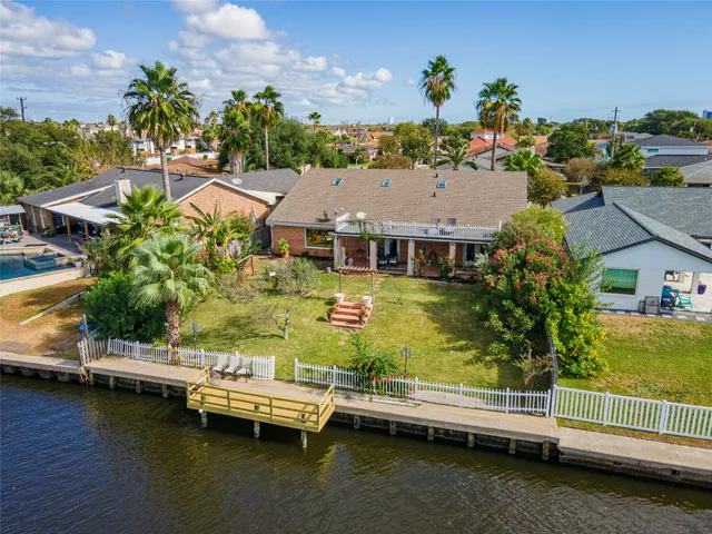 an aerial view of a house with a garden and lake view