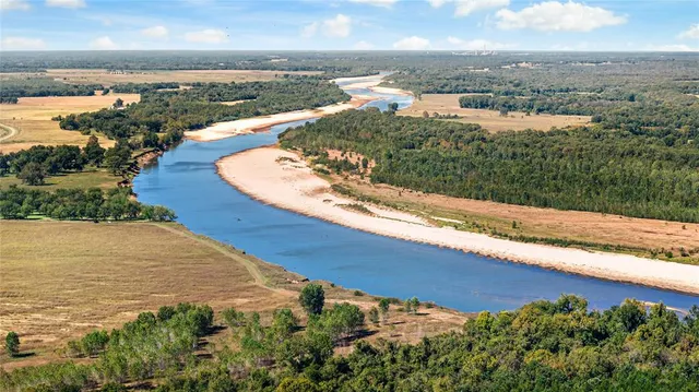 an aerial view of ocean and residential houses with outdoor space