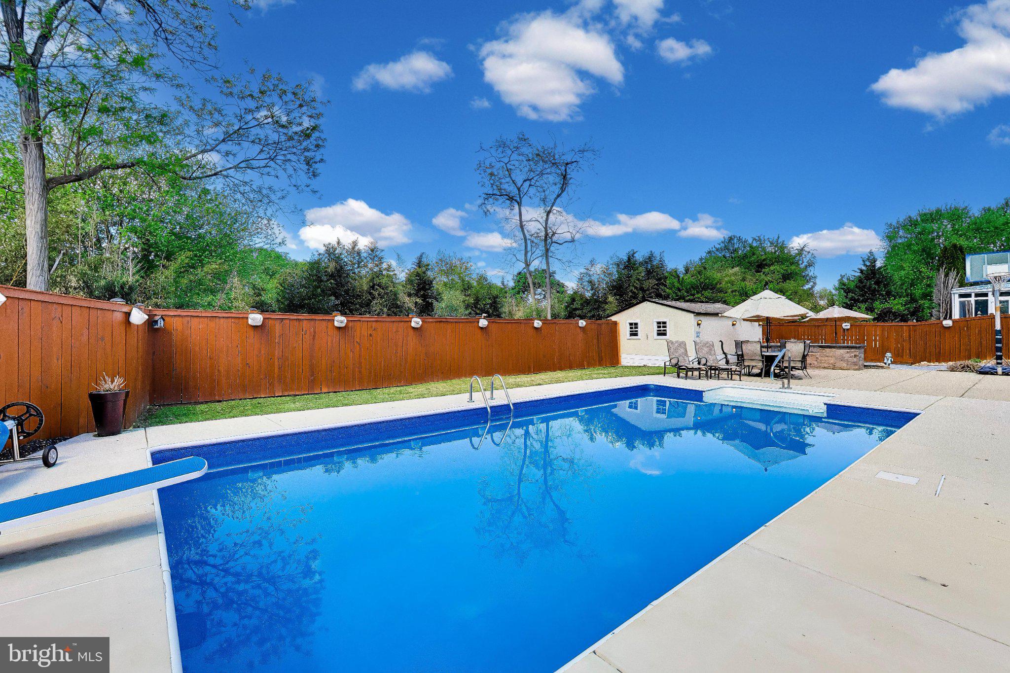 14216 Alderton Road Silver Spring, MD 20906 - Photo 42 of 63 a view of swimming pool with seating area and trees in the background