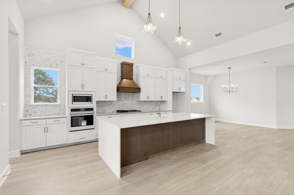 2005 Sundown Trail Georgetown, TX 78628 - Photo 3 of 18 a large kitchen with stainless steel appliances kitchen island a large counter tops and a view of living room