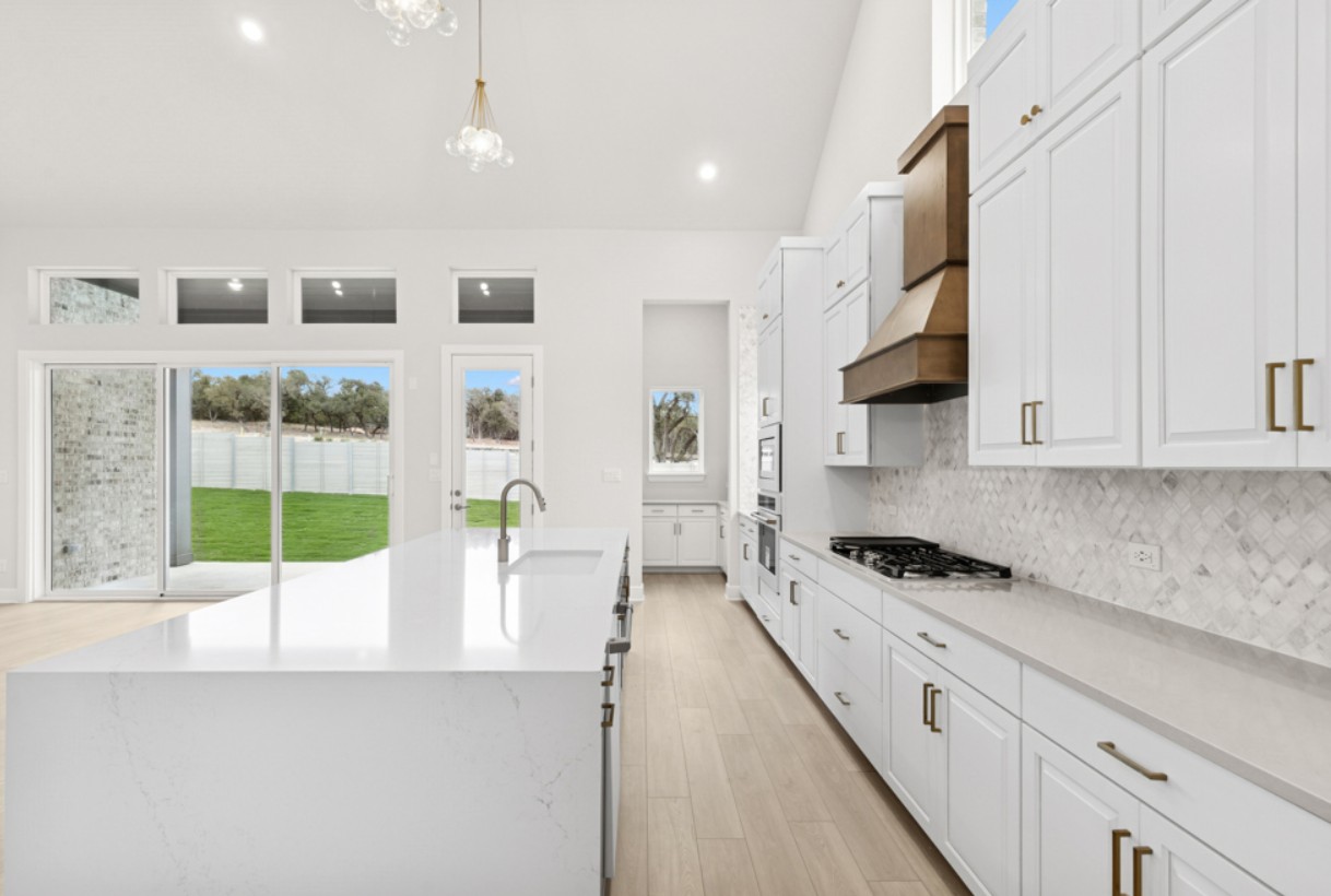 2005 Sundown Trail Georgetown, TX 78628 - Photo 4 of 18 a kitchen with stainless steel appliances kitchen island granite countertop a sink and cabinets