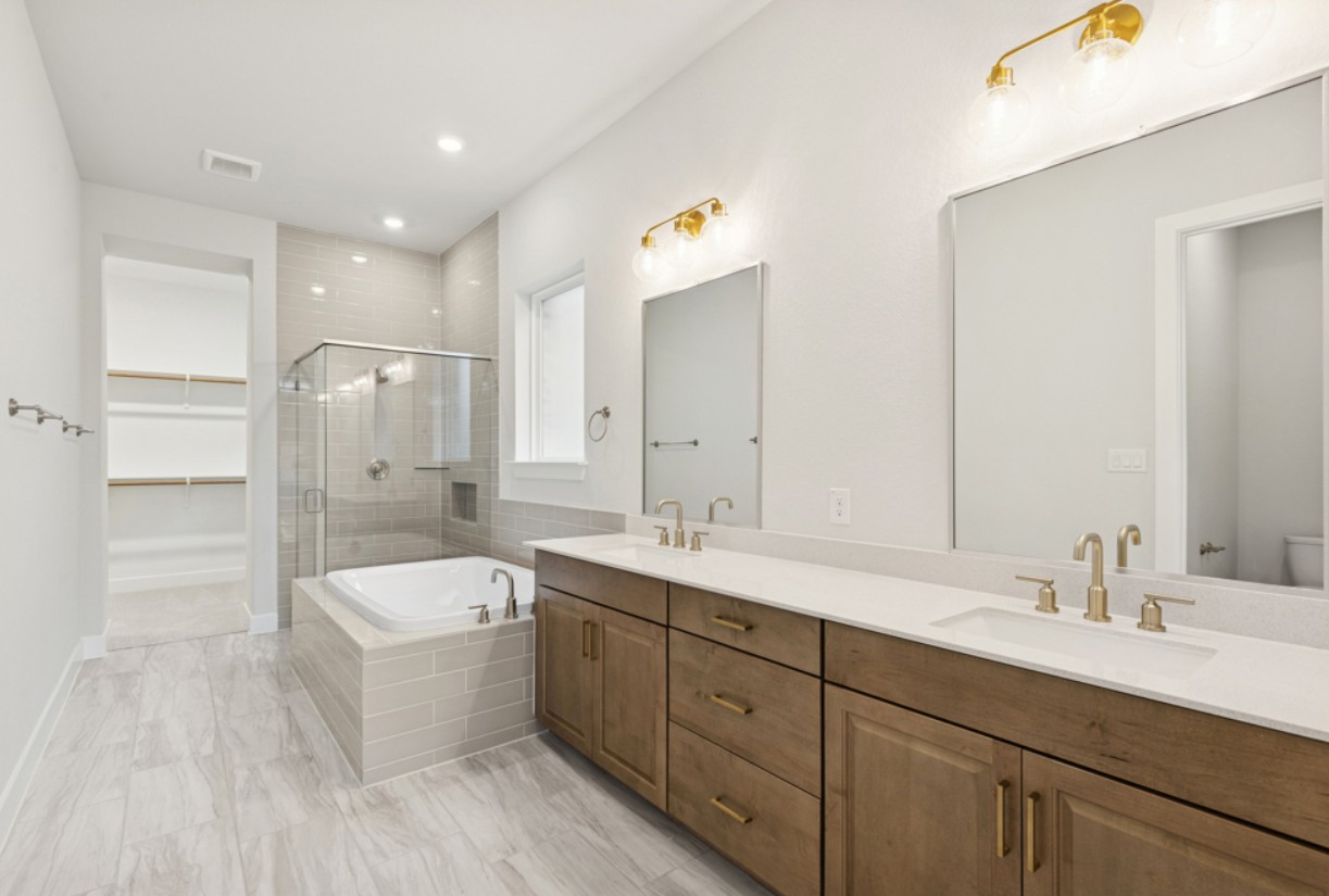 2005 Sundown Trail Georgetown, TX 78628 - Photo 9 of 18 a bathroom with a double vanity sink a mirror and a bathtub