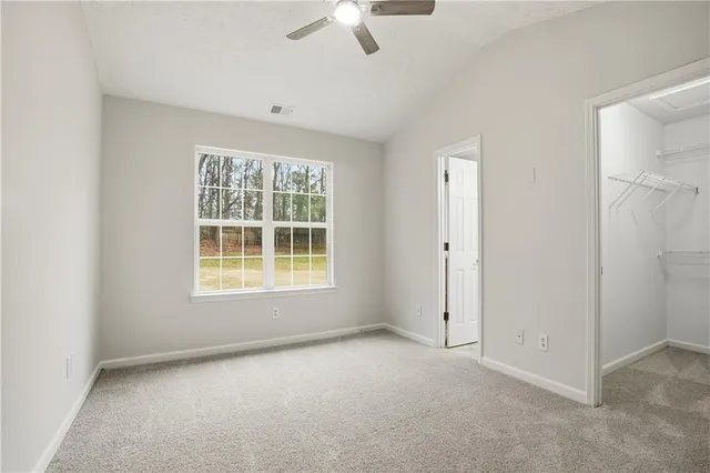 an empty room with a ceiling fan and a window