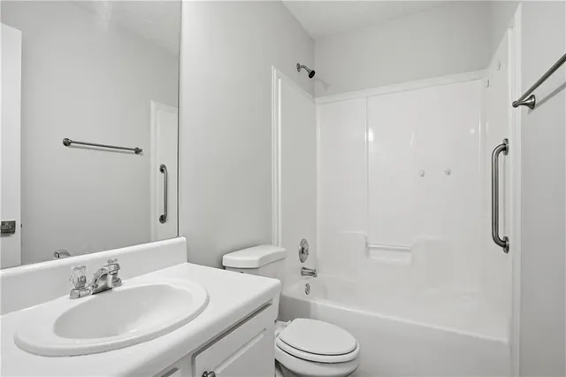 a bathroom with a toilet a sink a mirror and shower