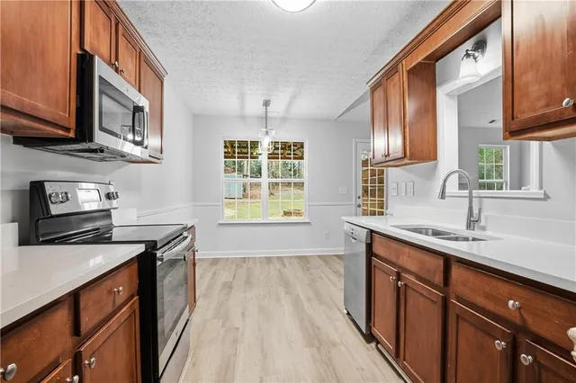a kitchen with stainless steel appliances granite countertop a sink stove and cabinets