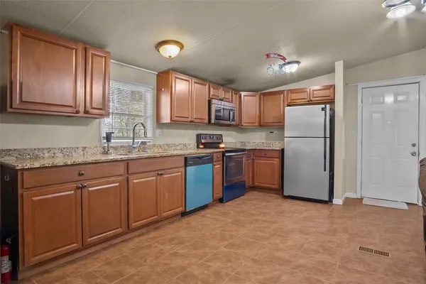 a kitchen with stainless steel appliances granite countertop a refrigerator sink and cabinets