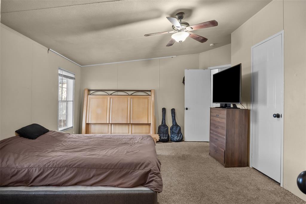 353 Prairie Lane Azle, TX 76020 - Photo 17 of 36 a bedroom with a bed and a flat screen tv