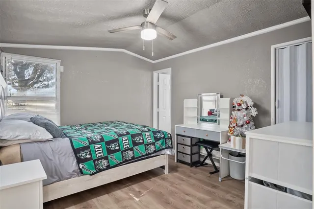 a spacious bedroom with a large bed and a chandelier