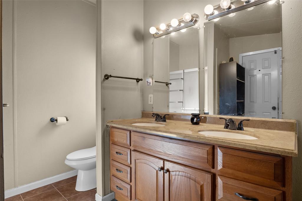 353 Prairie Lane Azle, TX 76020 - Photo 21 of 36 a bathroom with a granite countertop sink toilet a large mirror and shower