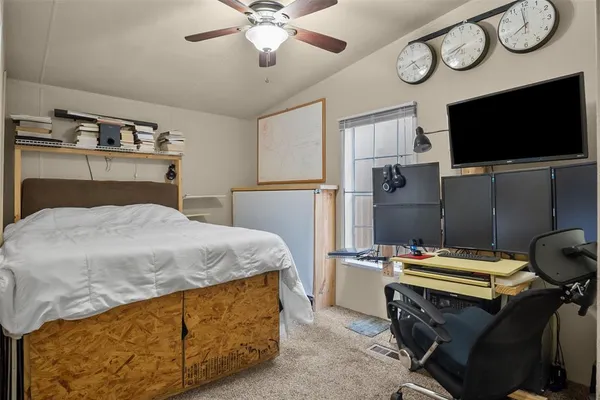 a bedroom with a bed and a flat tv screen on the dresser