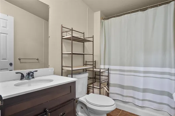 a bathroom with a sink a toilet a mirror and shower curtain