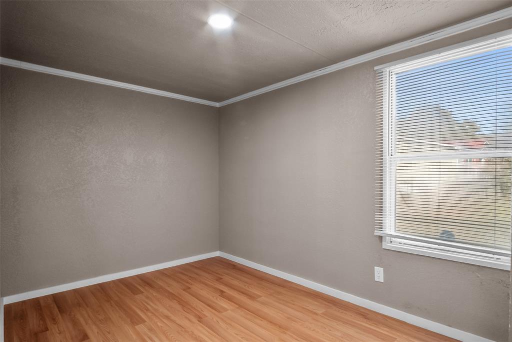 353 Prairie Lane Azle, TX 76020 - Photo 27 of 36 a view of an empty room with wooden floor and a window