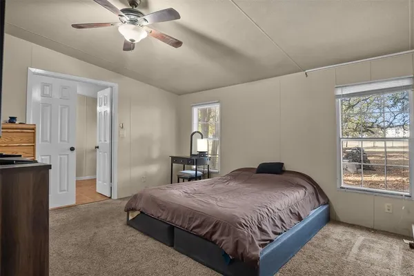 a spacious bedroom with a large bed and a chandelier