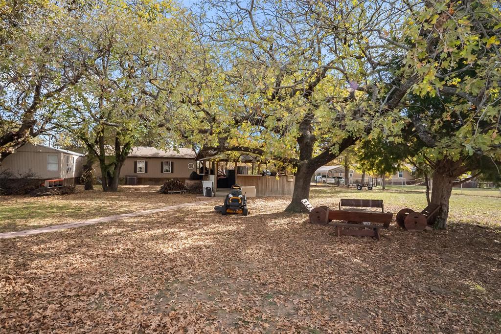 353 Prairie Lane Azle, TX 76020 - Photo 5 of 36 a view of a house with a yard covered in the forest