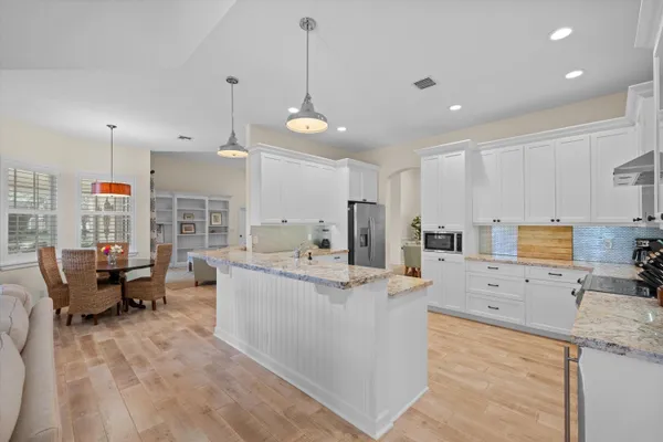 a dining room with furniture a chandelier and wooden floor