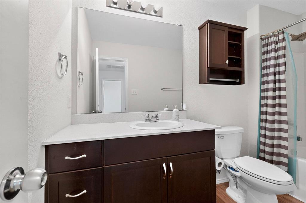5516 McClelland Street Forney, TX 75126 - Photo 20 of 36 Full bath featuring vanity, a textured wall, shower / tub combo, and wood finished floors