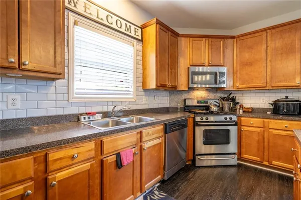 a kitchen with stainless steel appliances granite countertop wooden cabinets a sink and a stove