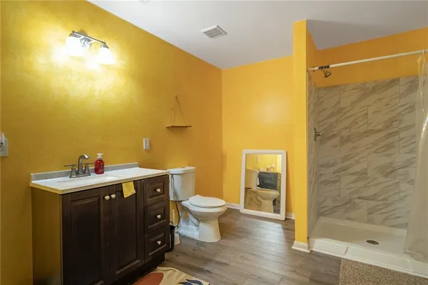 a bathroom with a sink mirror toilet and next to a shower