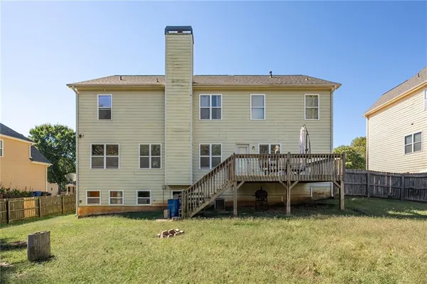 a view of a house with a backyard and furniture
