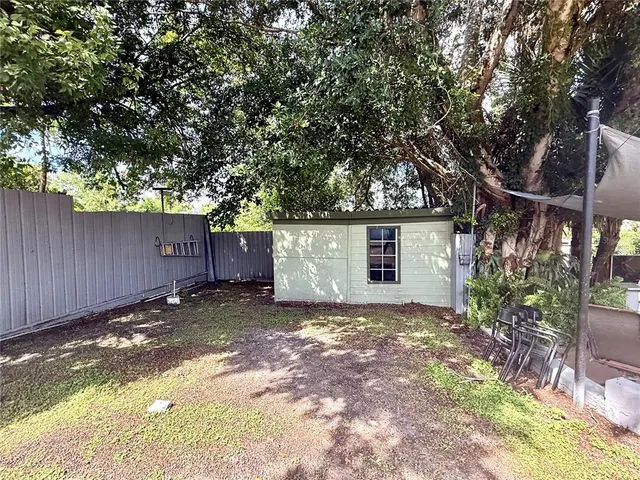 a view of a house with a large tree and a yard