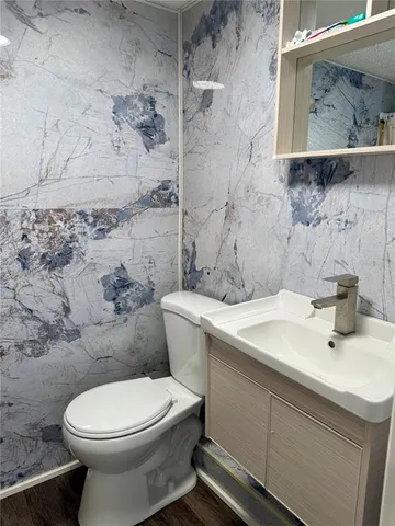 a bathroom with a sink a toilet and a mirror