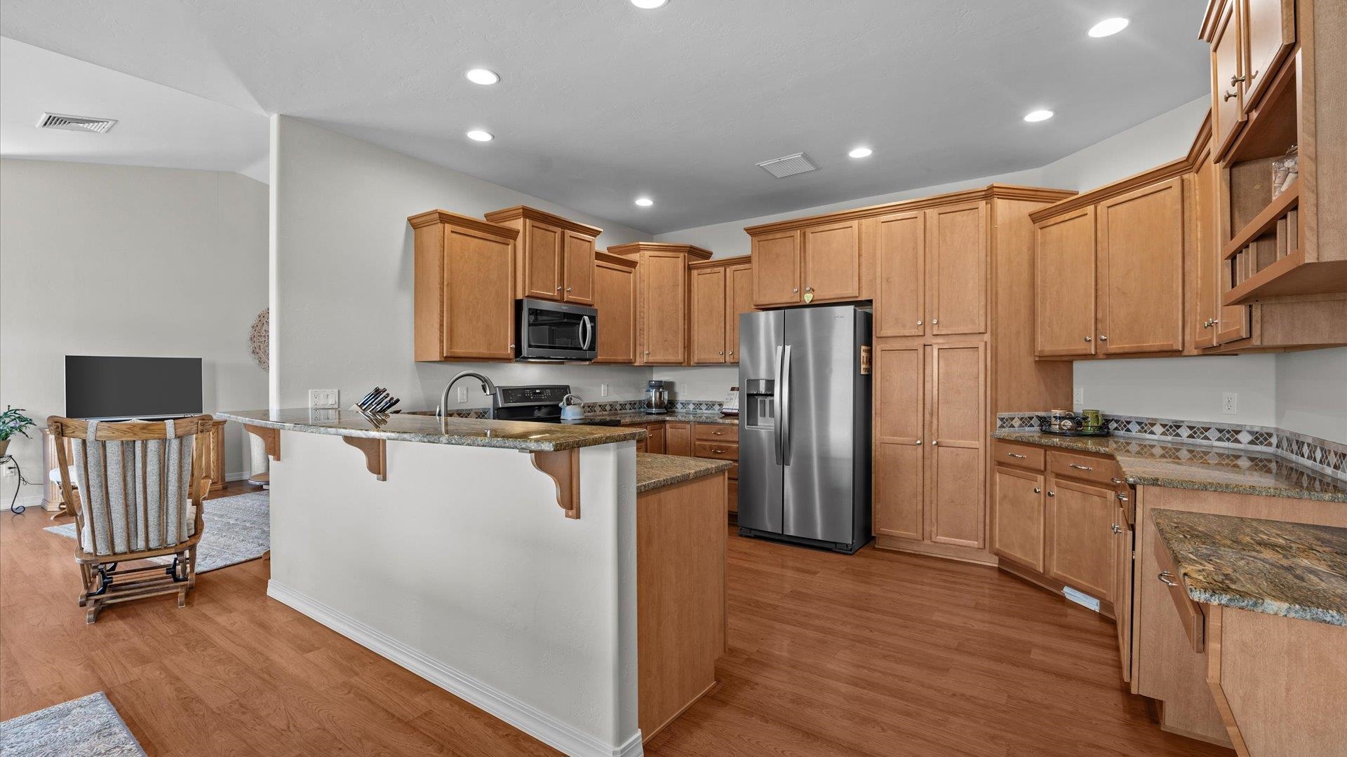 640 Beech Avenue Fruita, CO 81521 - Photo 15 of 34 a kitchen with a refrigerator a stove top oven a sink dishwasher and white cabinets with wooden floor