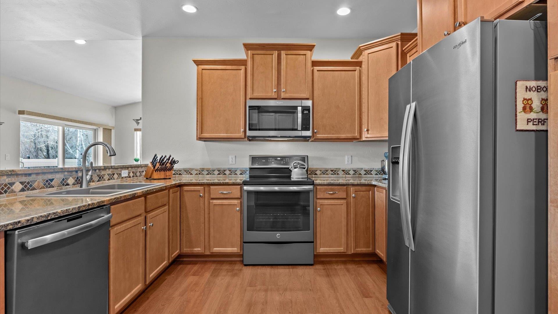 640 Beech Avenue Fruita, CO 81521 - Photo 16 of 34 a kitchen with stainless steel appliances granite countertop a refrigerator stove top oven and sink