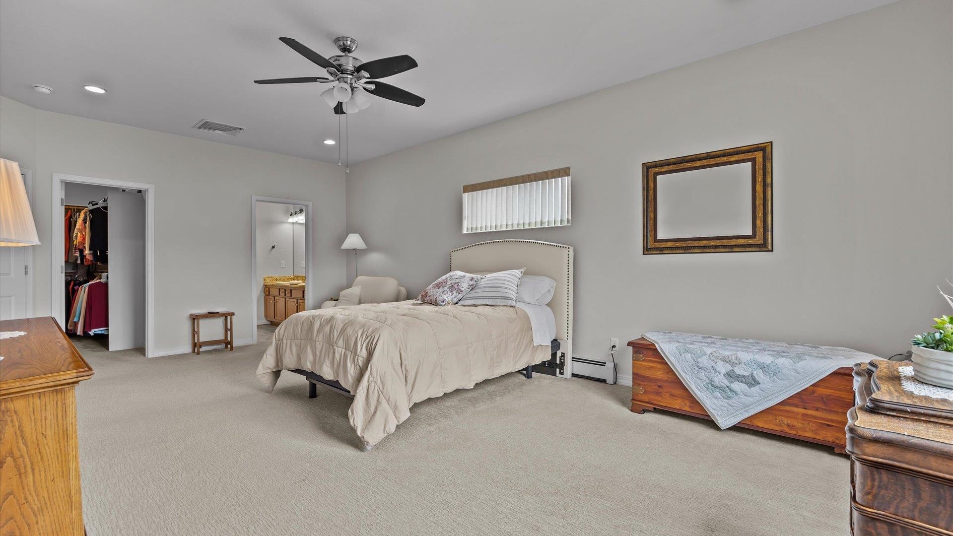 640 Beech Avenue Fruita, CO 81521 - Photo 20 of 34 a spacious bedroom with a bed and a chandelier