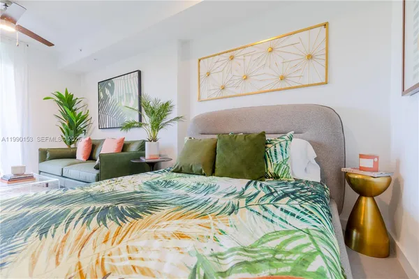 a bedroom with a bed and a potted plant