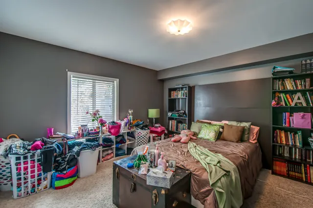 a living room with furniture a bookshelf and a window