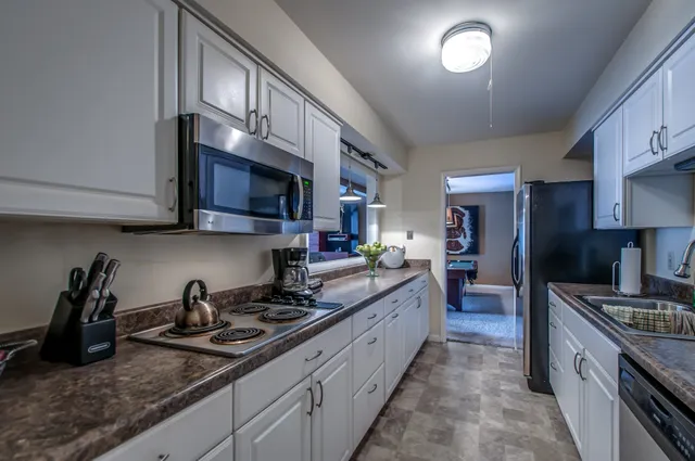 a kitchen with stainless steel appliances granite countertop a sink stove and cabinets