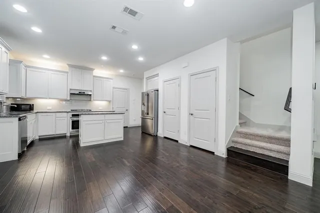a kitchen with white cabinets and stainless steel appliances
