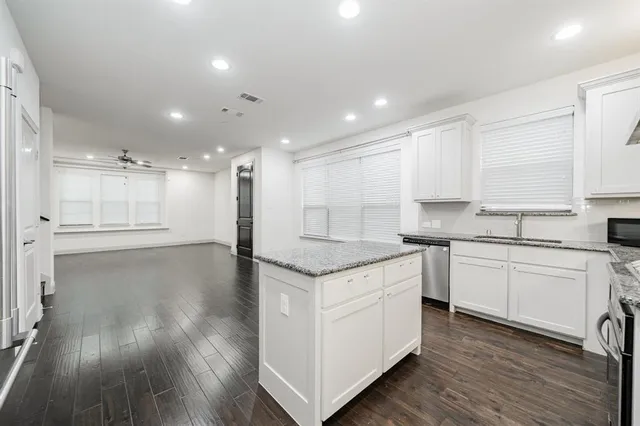 a kitchen with a stove top oven and white cabinets