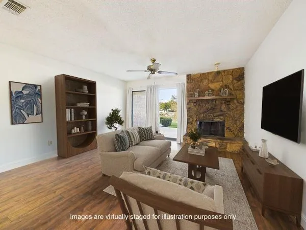 a view of an empty room with wooden floor and a ceiling fan