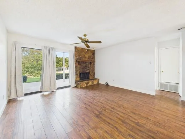 an empty room with wooden floor and a fireplace