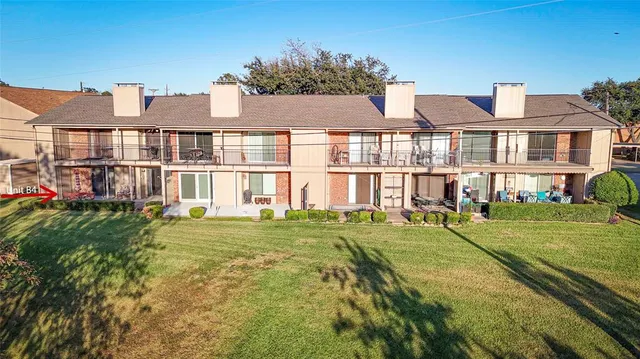 a view of a white house with a big yard and large trees