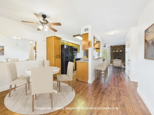 a living room with couches a dining table and chairs with wooden floor