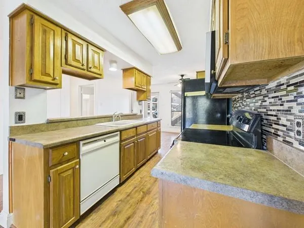 a view of a kitchen with wooden floor and a sink
