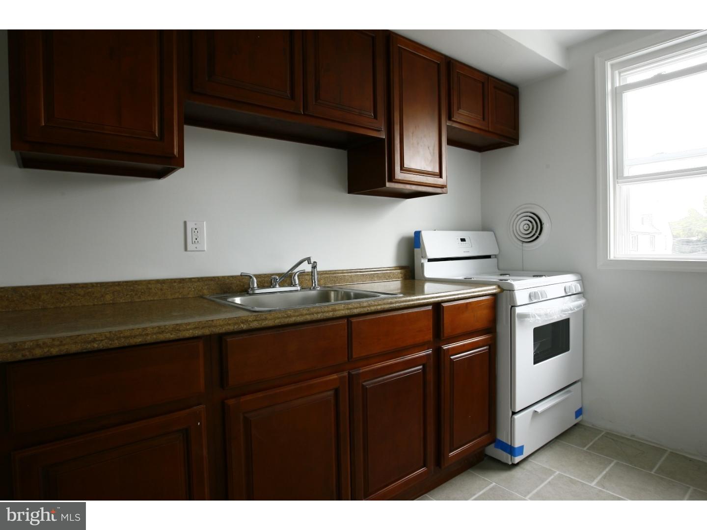 7136 Clinton Road Upper Darby, PA 19082 - Photo 1 of 10 a kitchen with stainless steel appliances a sink a stove a microwave cabinets and a window