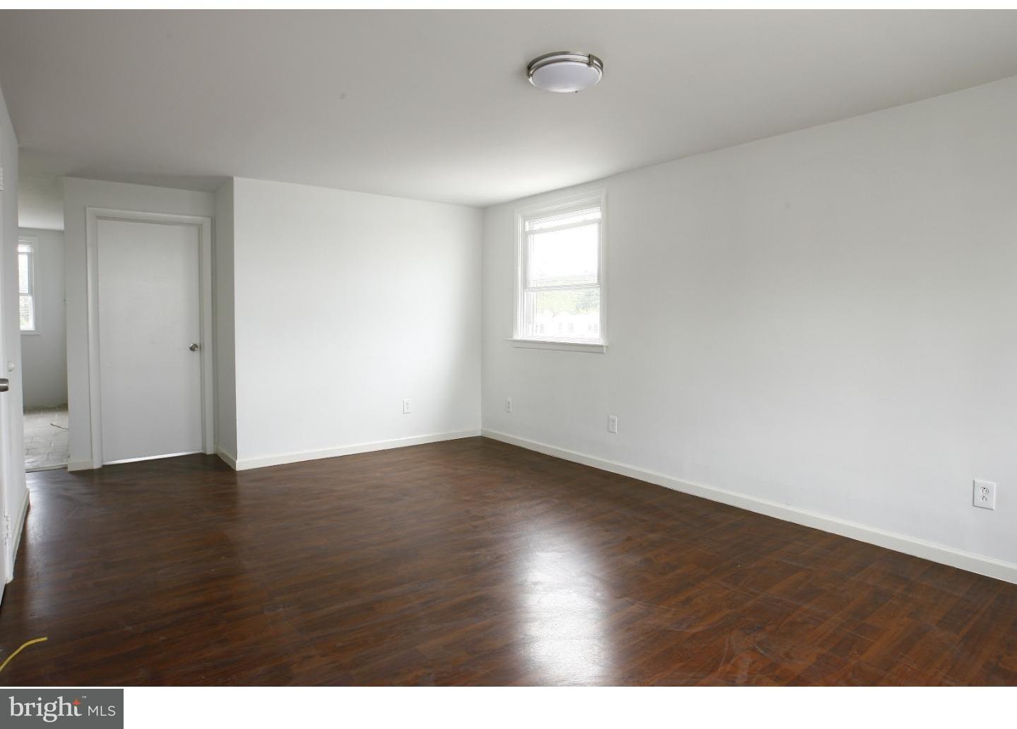 7136 Clinton Road Upper Darby, PA 19082 - Photo 5 of 10 a view of an empty room with wooden floor and a window