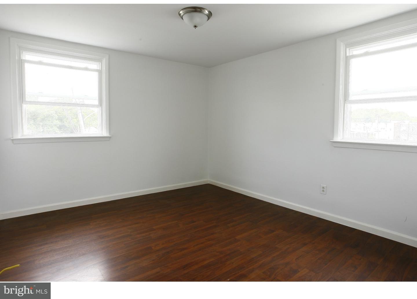 7136 Clinton Road Upper Darby, PA 19082 - Photo 8 of 10 an empty room with wooden floor and windows