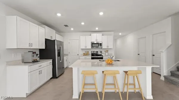 a kitchen with stainless steel appliances kitchen island granite countertop a refrigerator and a stove top oven