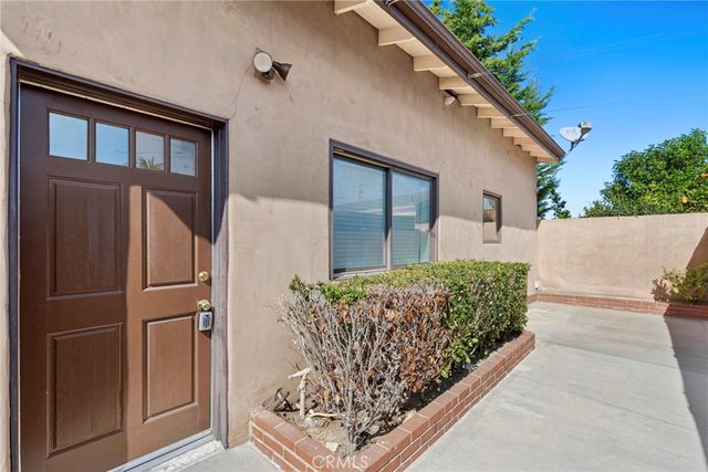 a front view of a house with plants