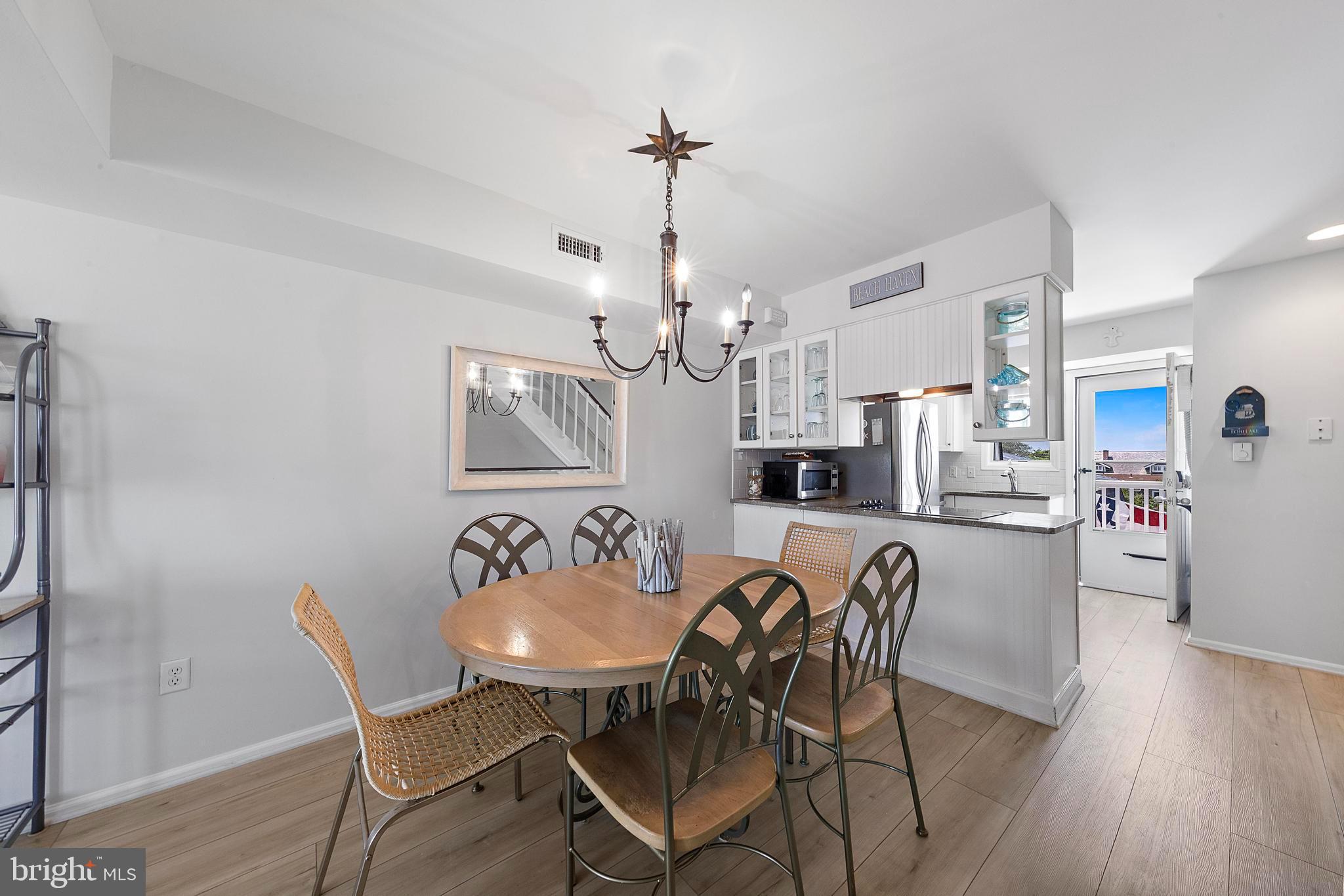1 Centre Street, Unit 1 Beach Haven, NJ 08008 - Photo 9 of 40 a dining room with furniture a chandelier and wooden floor