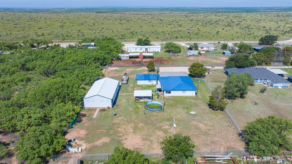 8867 Spinks Road Abilene, TX 79603 - Photo 1 of 9 Looking at the House West. Shop has white roof. House has blue