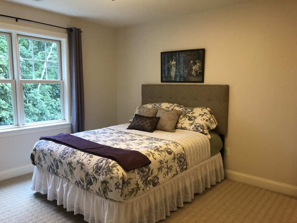 6 Adams Farm Road, Unit 6 Shrewsbury, MA 01545 - Photo 28 of 38 a bed sitting in a bedroom next to a window