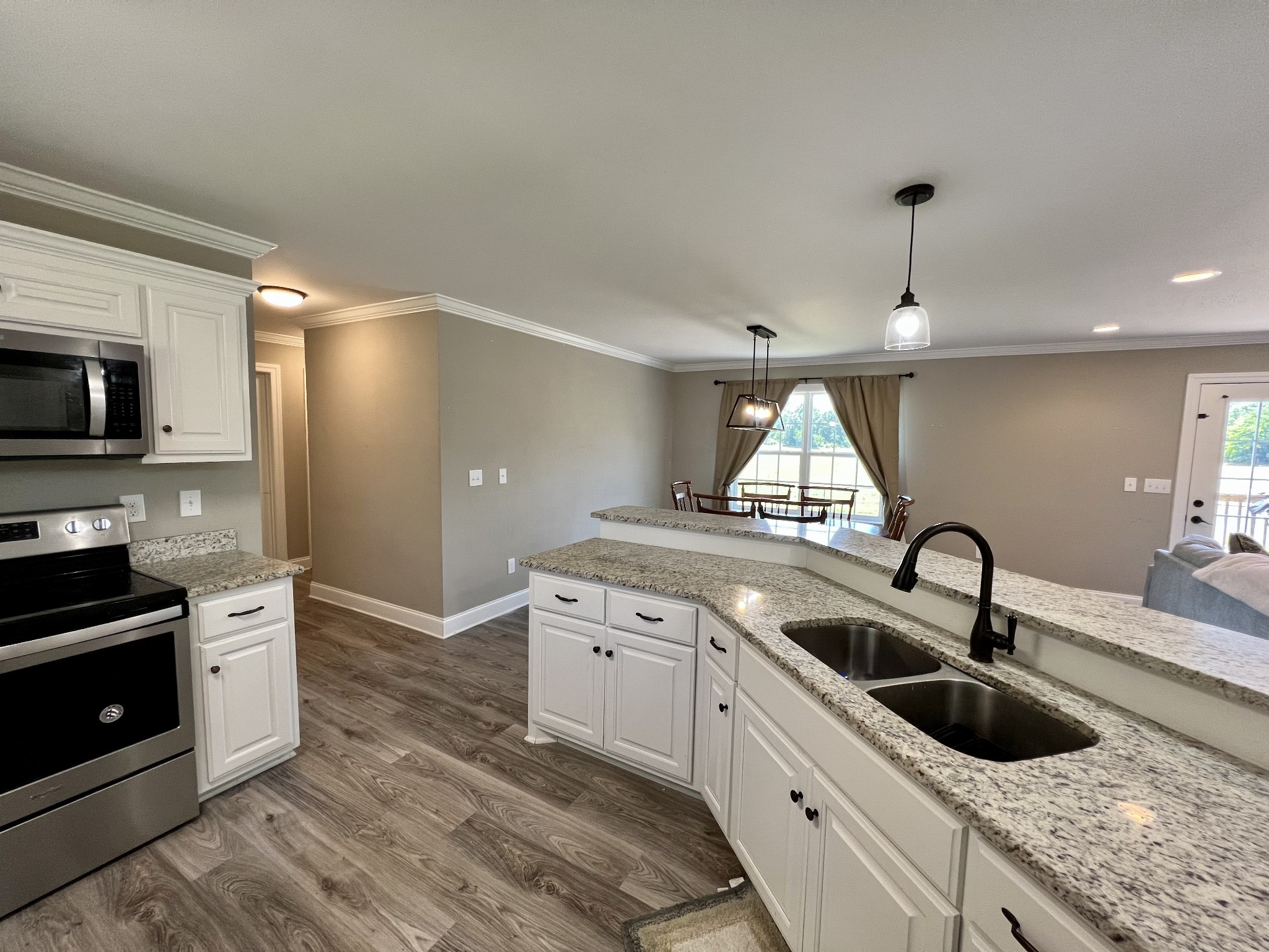 418 Taylor Road Manchester, TN 37355 - Photo 9 of 30 a kitchen with granite countertop a sink and a stove top oven with wooden floor