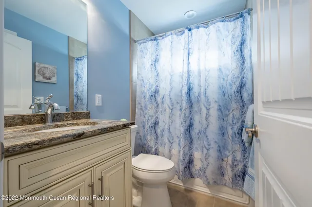 a bathroom with a granite countertop sink toilet and shower