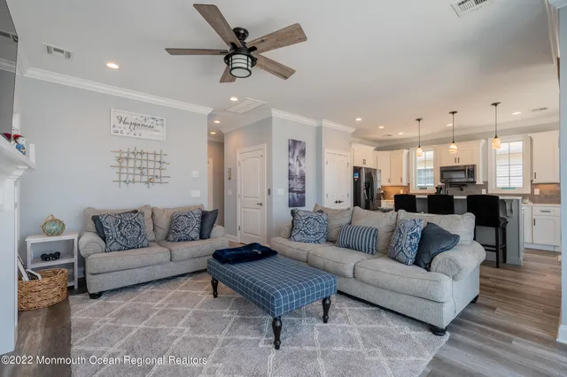 a living room with furniture and a view of kitchen